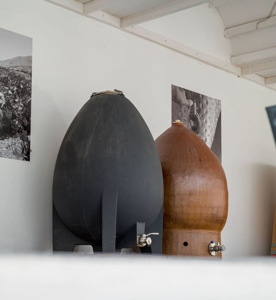 A captivating image of two barrels, one grey and the other brown, each equipped with valves expertly pouring wine into elegant glasses. A harmonious blend of rustic charm and the pleasures of indulging in fine wine.